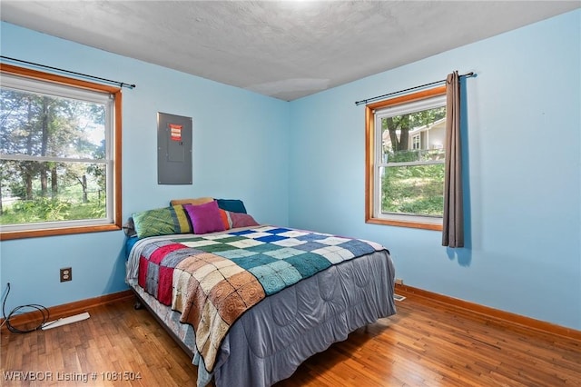 1310 Pigeon Creek Rd, Mountainburg, AR 72946 - bedroom featuring electric panel, multiple windows, and wood-type flooring