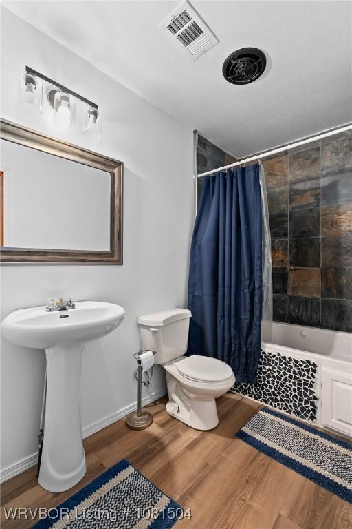 1310 Pigeon Creek Rd, Mountainburg, AR 72946 - bathroom with wood finished floors and tiled shower / bath combo