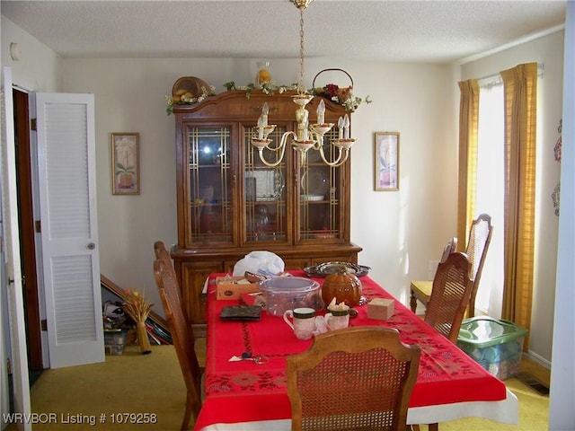 carpeted dining area featuring a textured ceiling and an inviting chandelier