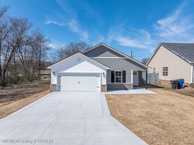 view of front of property featuring a front yard, brick siding, driveway, and an attached garage