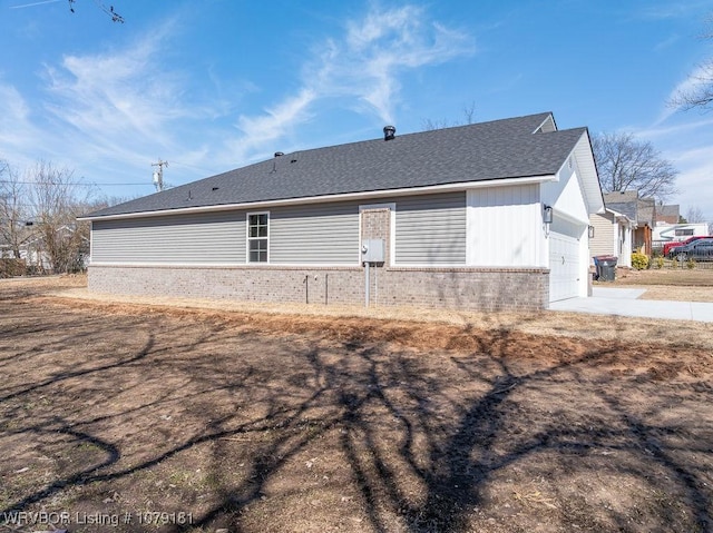 exterior space featuring driveway, brick siding, roof with shingles, and an attached garage