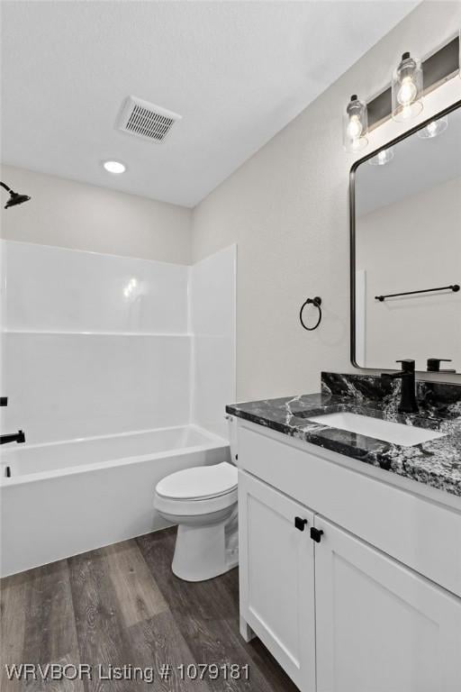 full bathroom with toilet, wood finished floors, vanity, visible vents, and shower / washtub combination