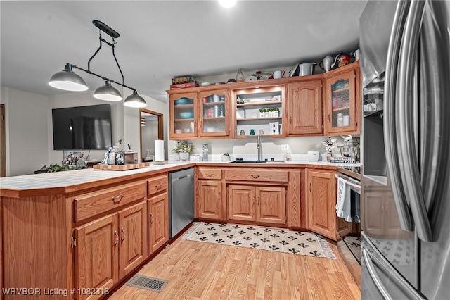 106078 S 4715th Rd, Muldrow, OK 74948 - kitchen with appliances with stainless steel finishes, a peninsula, light wood-style floors, and brown cabinetry