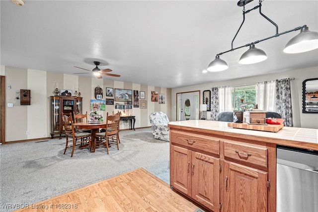106078 S 4715th Rd, Muldrow, OK 74948 - kitchen with dishwasher, tile countertops, light colored carpet, a ceiling fan, and brown cabinetry