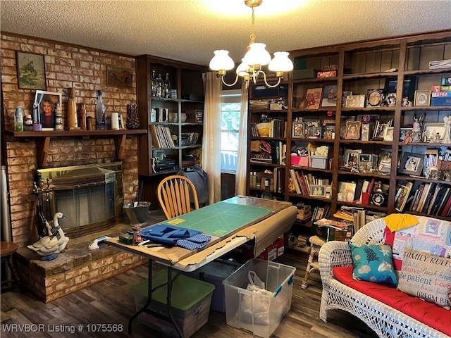 office area with a chandelier, wood-type flooring, a textured ceiling, and a fireplace