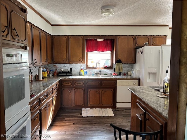 kitchen with white appliances, dark wood-type flooring, crown molding, sink, and a textured ceiling