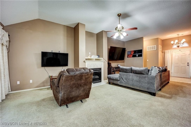 living room with ceiling fan with notable chandelier, light colored carpet, and vaulted ceiling