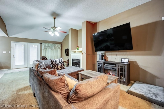 carpeted living room featuring a textured ceiling, vaulted ceiling, and ceiling fan