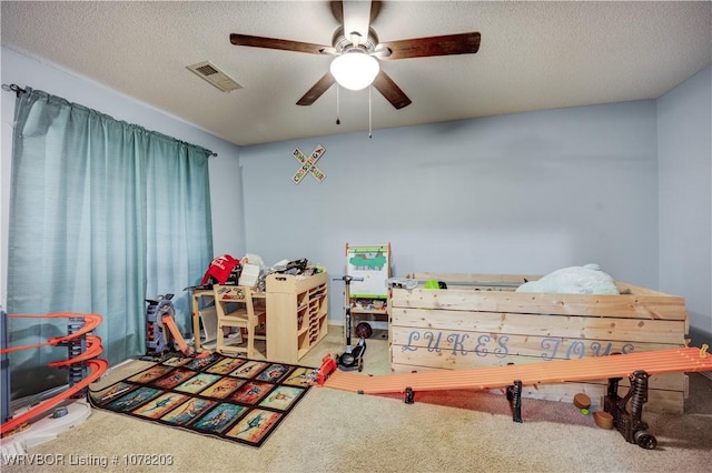 bedroom with carpet, a textured ceiling, and ceiling fan