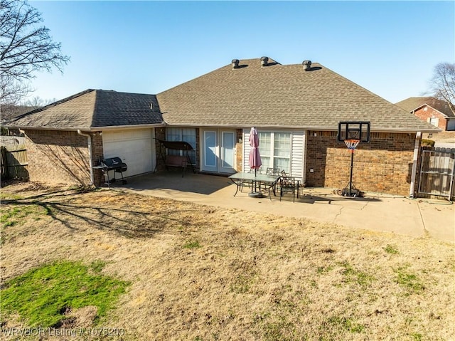 rear view of property featuring a garage and a patio area