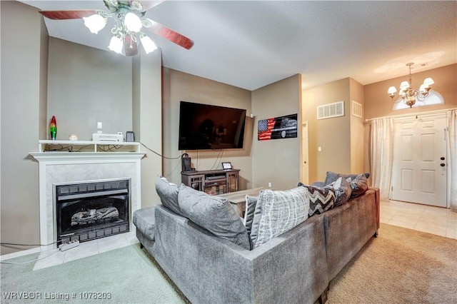 living room with ceiling fan with notable chandelier, light colored carpet, and a textured ceiling