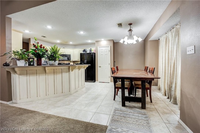 dining room with light tile patterned flooring, a textured ceiling, and a notable chandelier