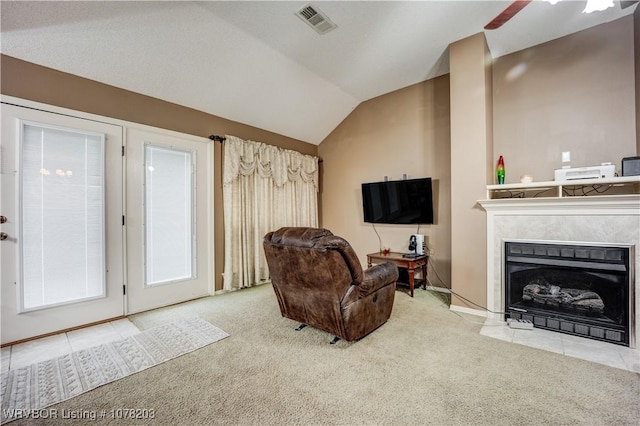 carpeted living room with ceiling fan and lofted ceiling