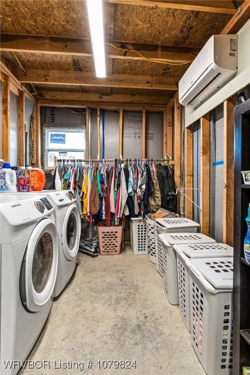 washroom with washer and clothes dryer, an AC wall unit, and laundry area