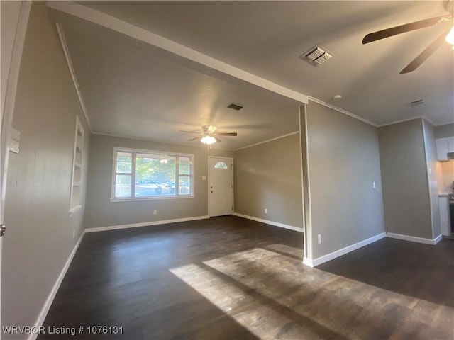 interior space with built in shelves, ceiling fan, dark hardwood / wood-style floors, and ornamental molding