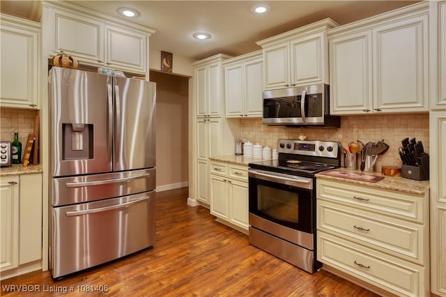 1326 56th Ter, Fort Smith, AR 72904 - kitchen with appliances with stainless steel finishes, wood finished floors, decorative backsplash, light stone counters, and recessed lighting