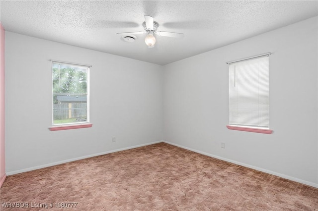carpeted spare room with a ceiling fan, a textured ceiling, and baseboards