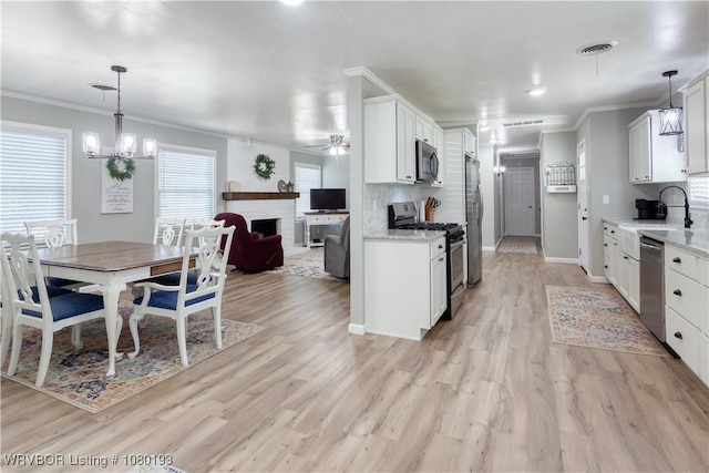 3811 Dallas St, Fort Smith, AR 72903 - kitchen with appliances with stainless steel finishes, ornamental molding, white cabinetry, open floor plan, and a sink