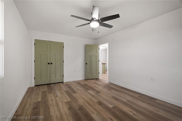 unfurnished bedroom with hardwood / wood-style flooring, ceiling fan, and a closet