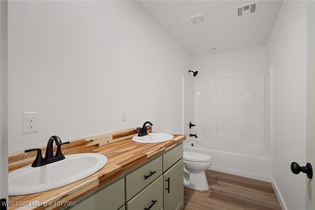 full bathroom featuring vanity, toilet, wood-type flooring, and bathing tub / shower combination