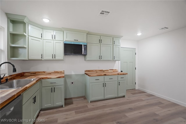 kitchen featuring stainless steel dishwasher, light hardwood / wood-style floors, butcher block counters, and sink