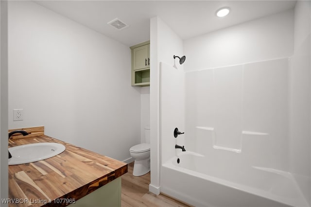 full bathroom featuring wood-type flooring, vanity, toilet, and shower / tub combination