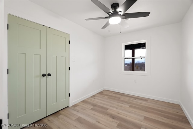 unfurnished bedroom with light hardwood / wood-style flooring, a closet, and ceiling fan