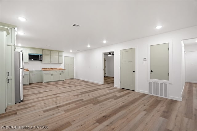 unfurnished living room with ceiling fan and light wood-type flooring