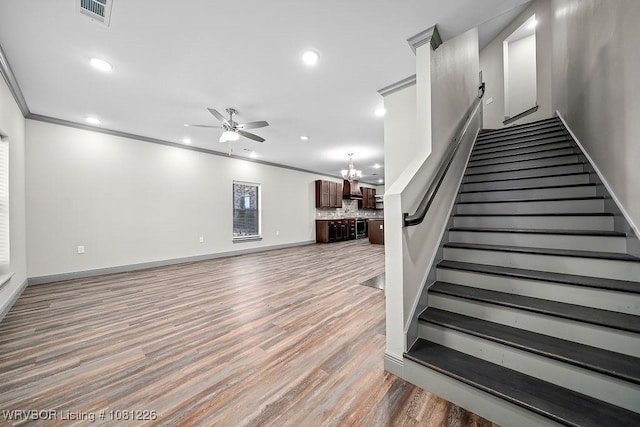 9205 R A Young Jr Dr, Fort Smith, AR 72916 - staircase with ceiling fan, a chandelier, wood finished floors, recessed lighting, and crown molding