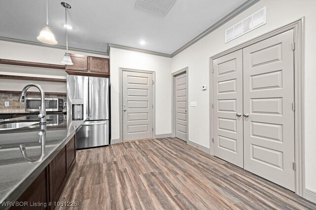 9205 R A Young Jr Dr, Fort Smith, AR 72916 - kitchen featuring stainless steel refrigerator with ice dispenser, ornamental molding, pendant lighting, wood finished floors, and open shelves