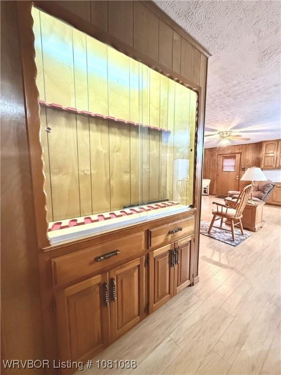 detailed view of a textured ceiling, wood finished floors, and ceiling fan