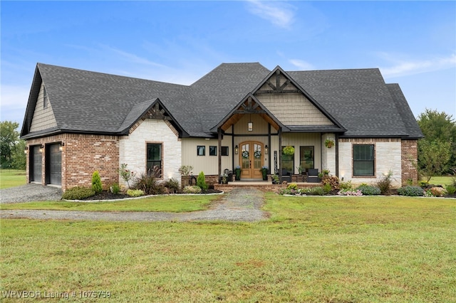 view of front of home with french doors, a garage, and a front lawn