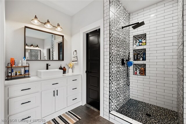 bathroom featuring a tile shower and vanity