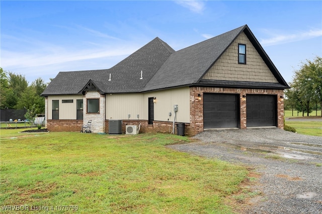 view of front of house with a garage, a trampoline, a front yard, and central AC