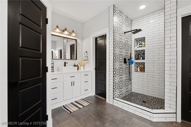 bathroom with vanity and tiled shower