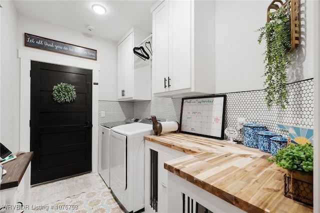 clothes washing area with cabinets, light tile patterned floors, and washing machine and dryer