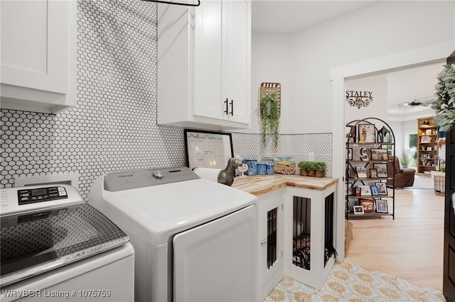 laundry area featuring washer and clothes dryer and cabinets