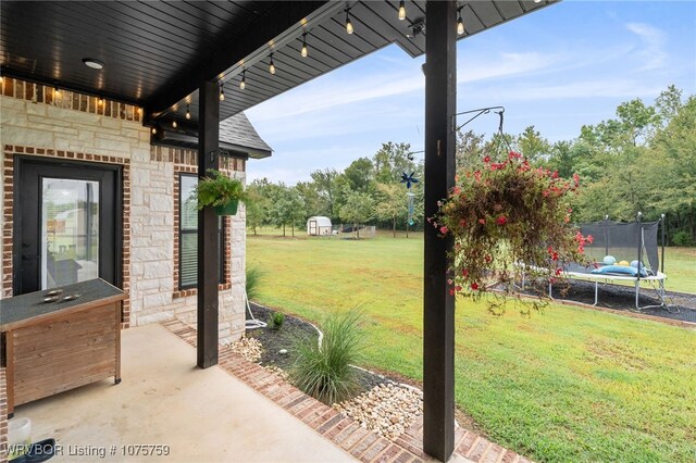 view of yard featuring a patio and a trampoline