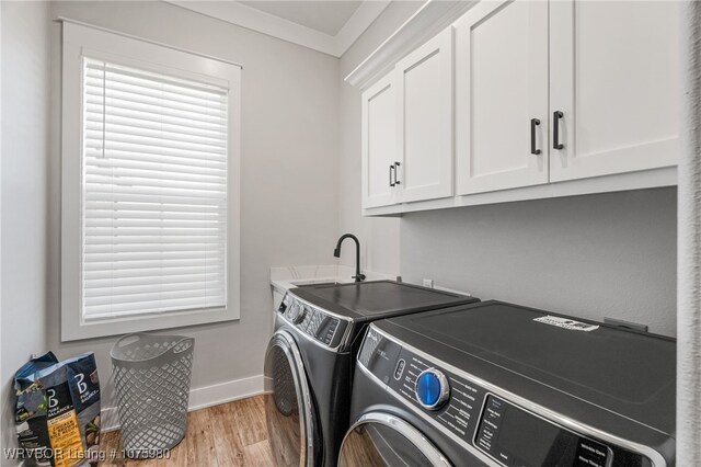 laundry area with sink, cabinets, washing machine and dryer, light hardwood / wood-style flooring, and ornamental molding