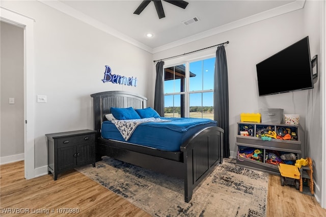 bedroom featuring ceiling fan, light wood-type flooring, and ornamental molding