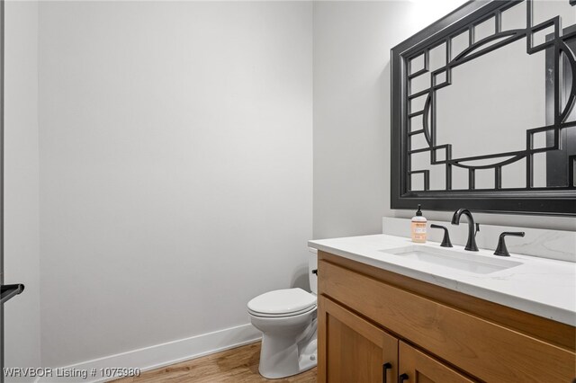 bathroom with hardwood / wood-style floors, vanity, and toilet