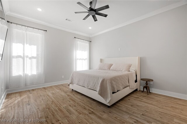 bedroom featuring ceiling fan, crown molding, and wood-type flooring