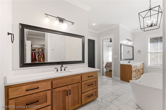 bathroom featuring a washtub, vanity, ceiling fan with notable chandelier, and ornamental molding