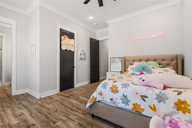 bedroom featuring hardwood / wood-style floors, ceiling fan, and crown molding