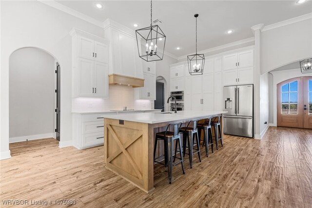 kitchen with white cabinets, a spacious island, stainless steel appliances, and french doors