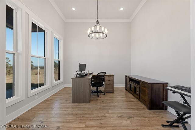 office area with a notable chandelier, plenty of natural light, ornamental molding, and light hardwood / wood-style flooring