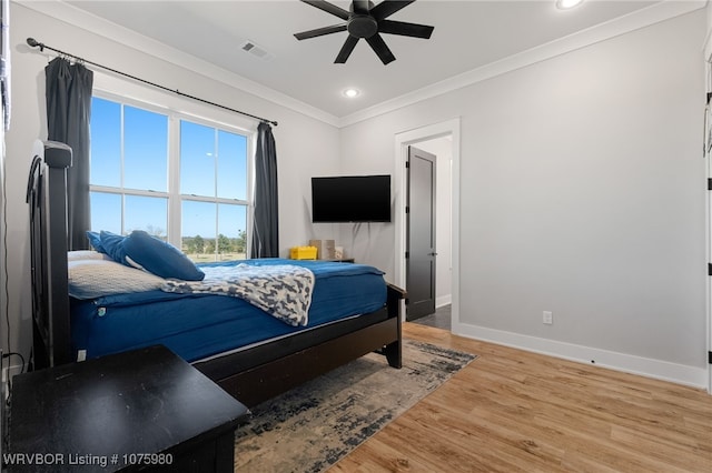 bedroom featuring ceiling fan, light hardwood / wood-style floors, and ornamental molding