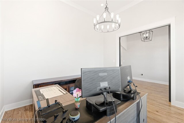 office with light hardwood / wood-style floors and an inviting chandelier