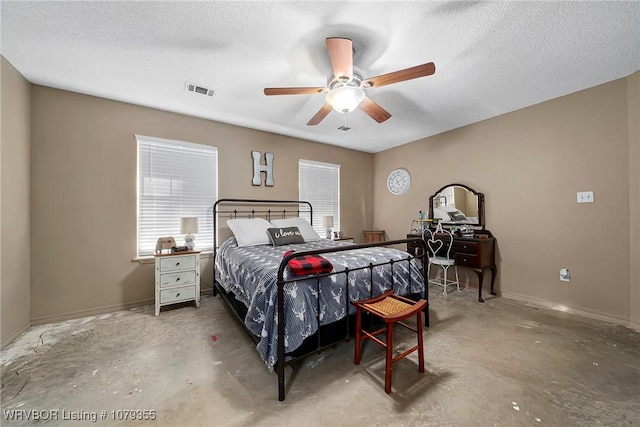 bedroom featuring a textured ceiling, ceiling fan, multiple windows, and visible vents