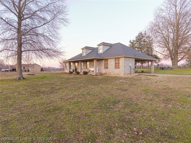 view of front facade featuring a carport, brick siding, and a front yard